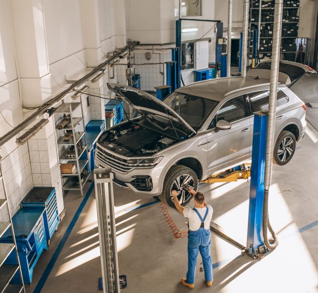 Auto mechanic checking car