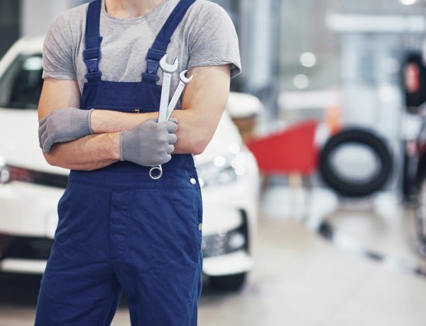 Hand of car mechanic with wrench. Auto repair garage.